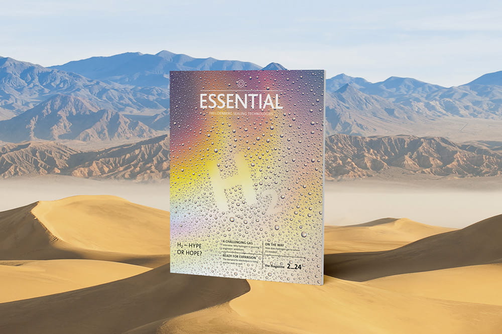 The Essential Edition H2 in rainbow colours stands in a desert. 